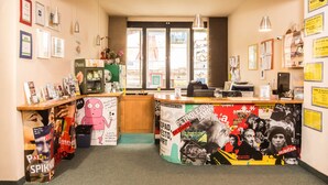 Un área de recepción con mostrador, certificados enmarcados en la pared y una ventana con vistas.