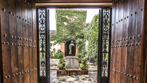 A stone-tiled entrance with a view of a garden and a stone bench. - Finca Villa Juan (Ribera del Fresno)