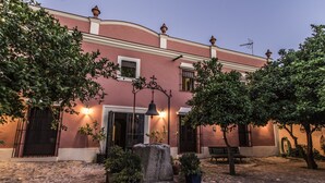 A courtyard with a stone fountain, potted plants, and a bench. - Finca Villa Juan (Ribera del Fresno)