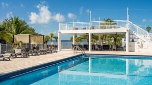 A pool area with lounge chairs and a covered seating area. - Brand New Key Largo Home (Key Largo)