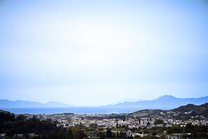 A coastal town with a view of the sea and mountains in the distance.