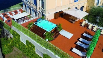 Relax and socialize on the rooftop terrace, featuring a pool, lounge chairs, and a table with umbrellas.