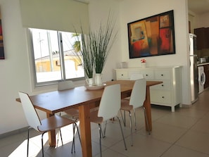 Una cocina moderna con comedor, un amplio ventanal y un cuadro en la pared.