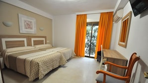 Habitación de hotel con cama doble, escritorio y silla.