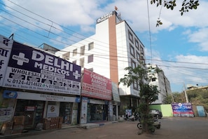 A building with multiple signs, including 'Delhi Medicos' and 'Gandhi Arogya'. - Kabul Hotel Medanta Hospital, Gurugram (Gurugram)