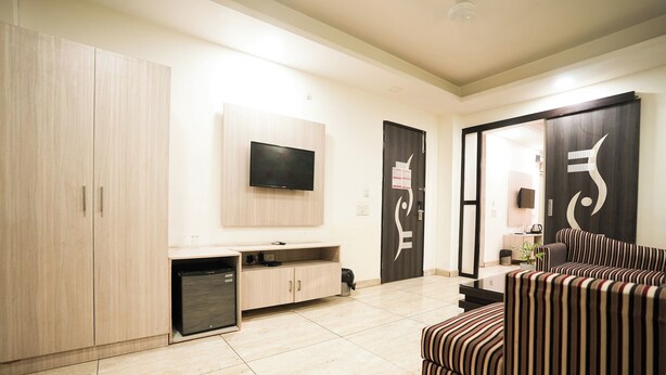 Una sala de estar moderna con un televisor montado en la pared, un sofá y un mueble de almacenamiento.