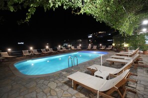 Una piscina al aire libre, tumbonas