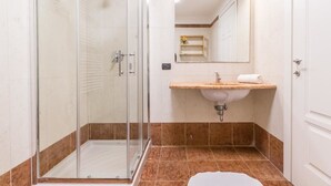 A bathroom with a glass-enclosed shower, a sink with a countertop, and a mirror above the sink. - Alessia's Flat - Portello 2 (Milan)