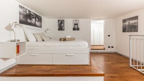 A bedroom with a bed, bedside tables, and a view of a cityscape through a window. - Alessia's Flat - Portello 2 (Milan)