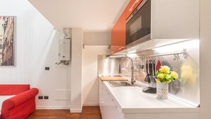 A modern kitchen with white cabinetry, a built-in oven, and a window with a view. - Alessia's Flat - Portello 2 (Milan)