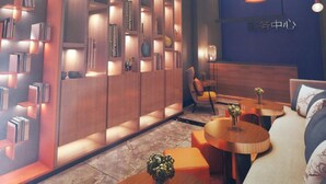 Un interior moderno con una estantería de madera, un sofá y una mesa redonda.
