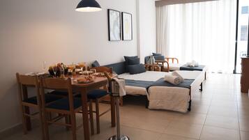 Een hotelkamer met een zithoek, een bed en een groot raam, plus een minibar.