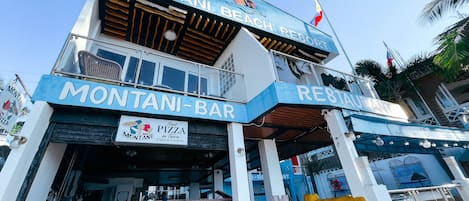 A two-story building with a sign for 'Montani-Bar' and 'Best Pizza in town'.