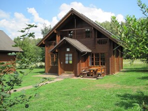 A wooden cabin with a front porch and a picnic table. - Ferienwohnpark Silbersee (Frielendorf)