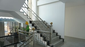 A modern staircase with metal railings and a glass balustrade, leading to an upper floor. - Chouaprom Mansion (Nakhon Si Thammarat)