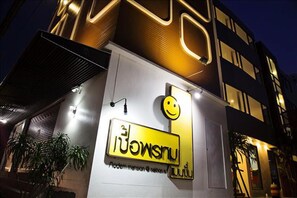 A building with a modern design, featuring a prominent sign with a smiley face and the text "Lonsu".