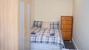 Un dormitorio con una cama, un armario de madera y un aparador.