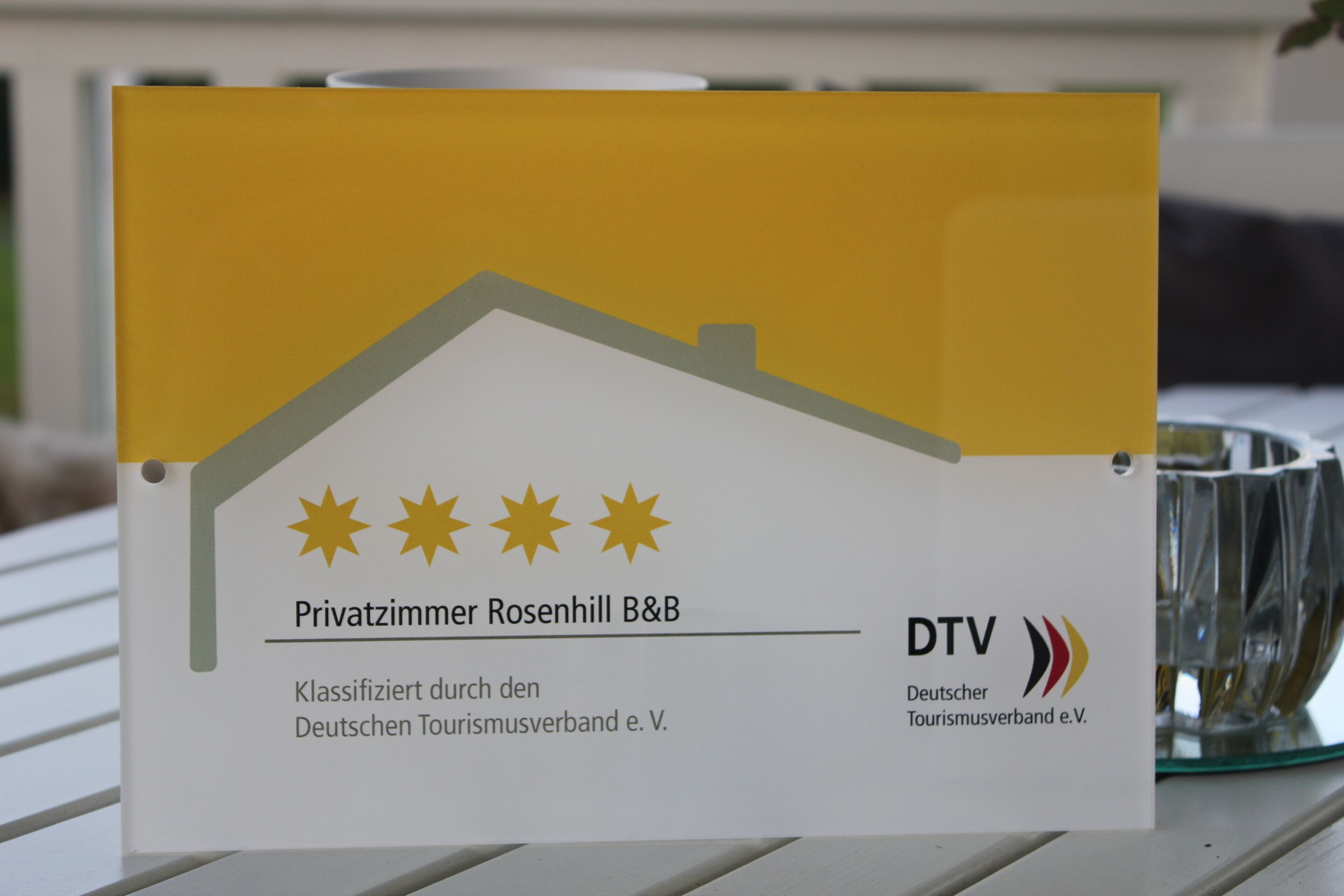Une enseigne indiquant le « Privatzimmer Rosenhill », un établissement proposant des chambres d’hôtes, classé par l’Association allemande du tourisme.