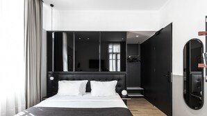 Una habitación de hotel moderna con una cama grande, un armario y un vestidor.
