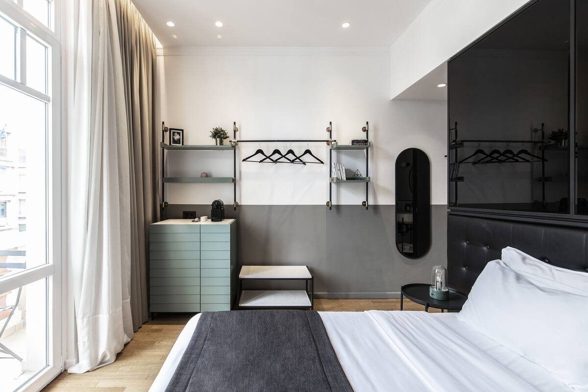 Ein modernes Schlafzimmer mit Bett, Kommode, Schminktisch und Spiegel.