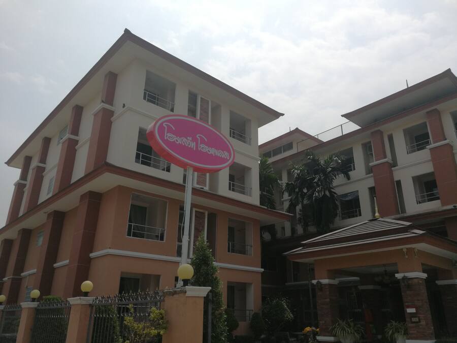 Un edificio de varios pisos con un cartel llamativo que dice "Poonam House".