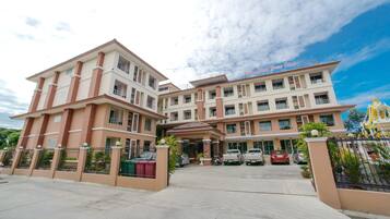 Hotel features a symmetrical facade with a central entrance and available parking.
