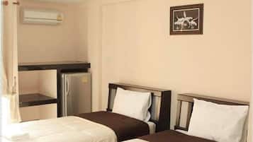 A hotel room with two beds, a kitchenette, and a ceiling light.