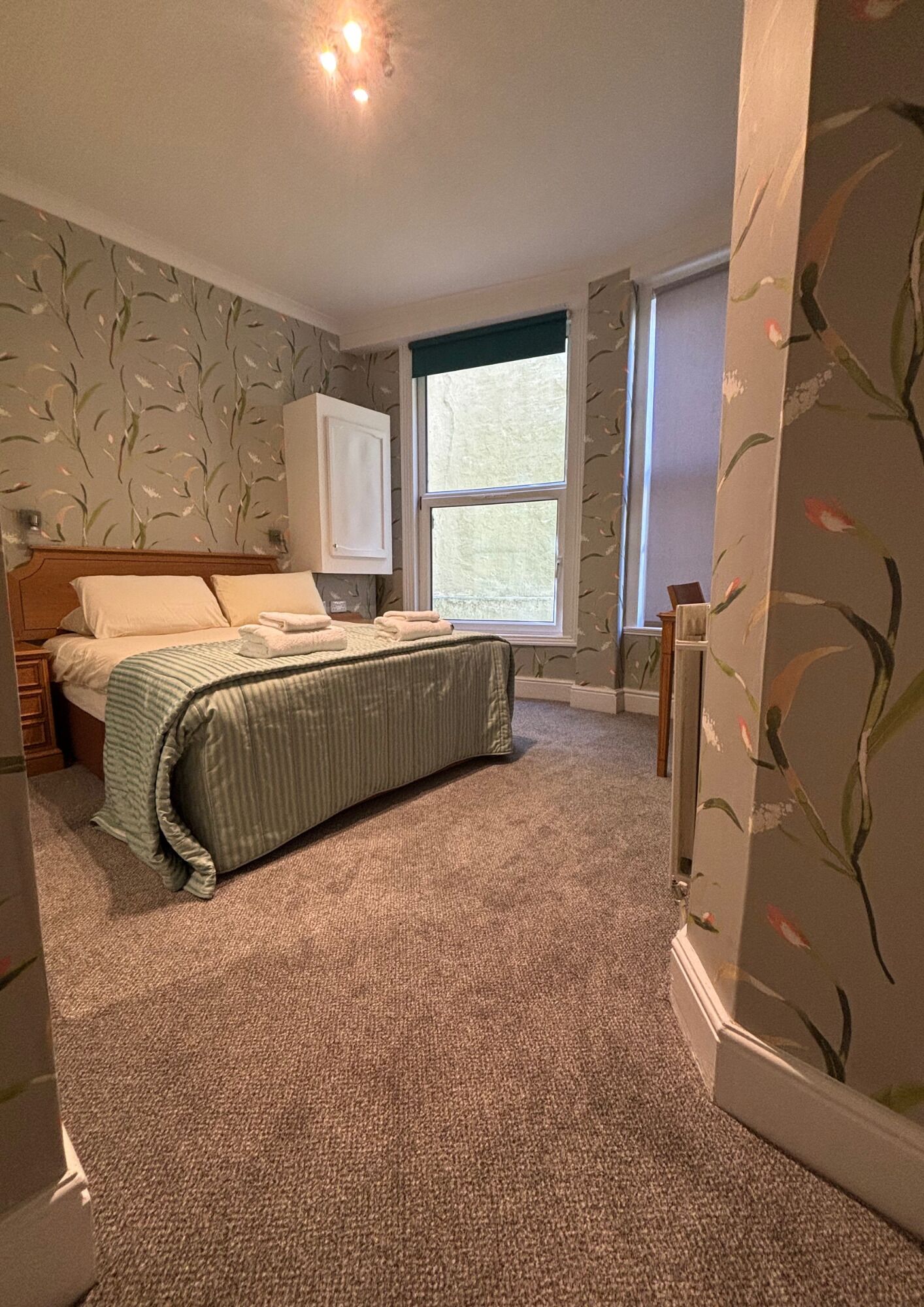 Une chambre à coucher avec un lit, une fenêtre et une porte.