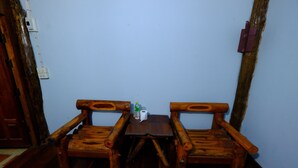 Un banco de madera con una pequeña mesa en el centro, una botella y una caja de pañuelos.