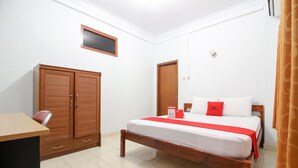 Een slaapkamer met een houten bed, een bureau en een kledingkast.