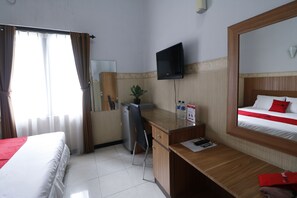 A hotel room with a bed, a desk, a chair, a television, and a mirror. - RedDoorz Plus near Undip Tembalang (Semarang)