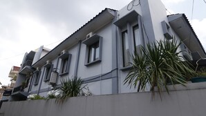 A modern two-story building with a grey facade, large windows, and a flat roof. - RedDoorz Plus near Undip Tembalang (Semarang)