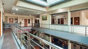 A multi-level interior with a central atrium, glass railings, and a gym sign.