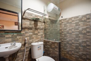 Une salle de bain équipée d’un lavabo, de toilettes et d’une douche à parois en verre.