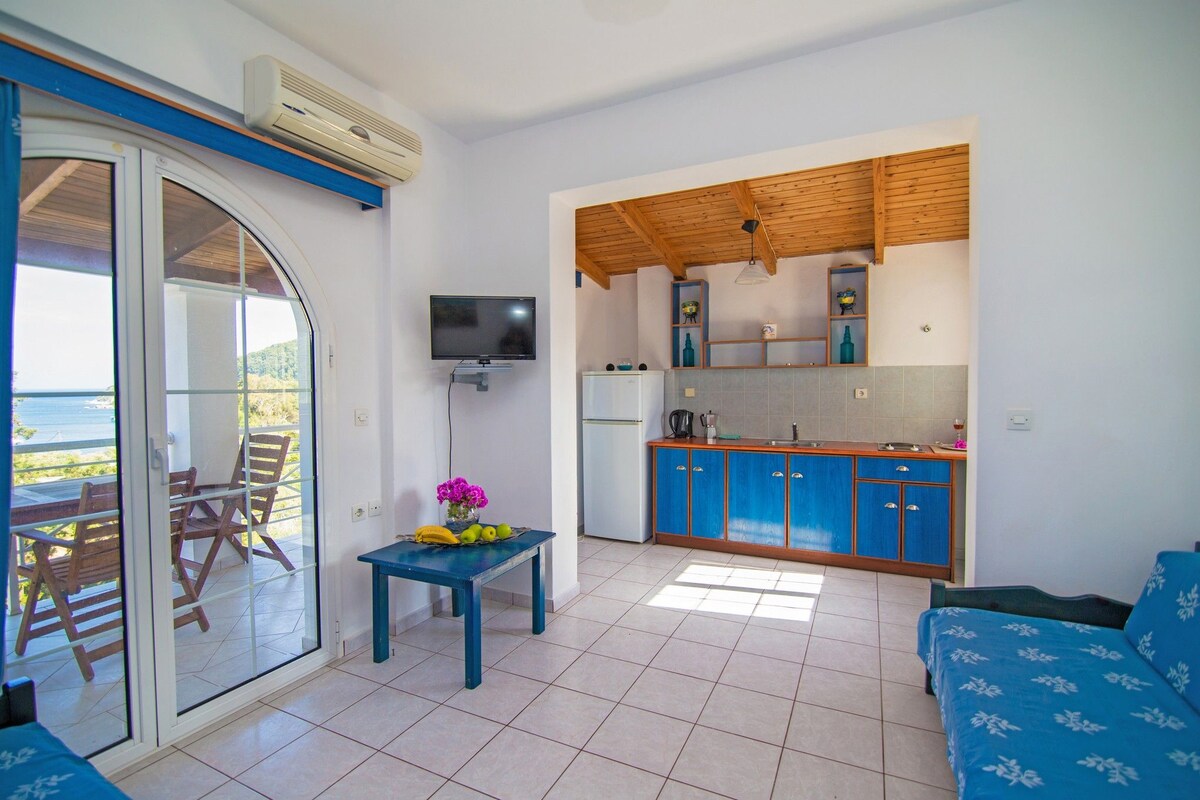 Un espace de vie compact doté d’un balcon, d’une kitchenette et d’un coin repas.