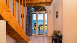 Una escalera de madera que lleva a un balcón con vistas al mar.