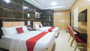 A hotel room with two beds, a desk, a chair, a television, and a framed picture on the wall. - RedDoorz @ Winter Hotel Araneta (Quezon City)