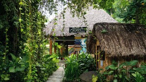 A thatched-roof structure labeled "Welcome to Michanti - Home of Adventures" with a signboard listing amenities like pool, aquarium, and long stay. - Hotel Michanti (Chiltiupan)