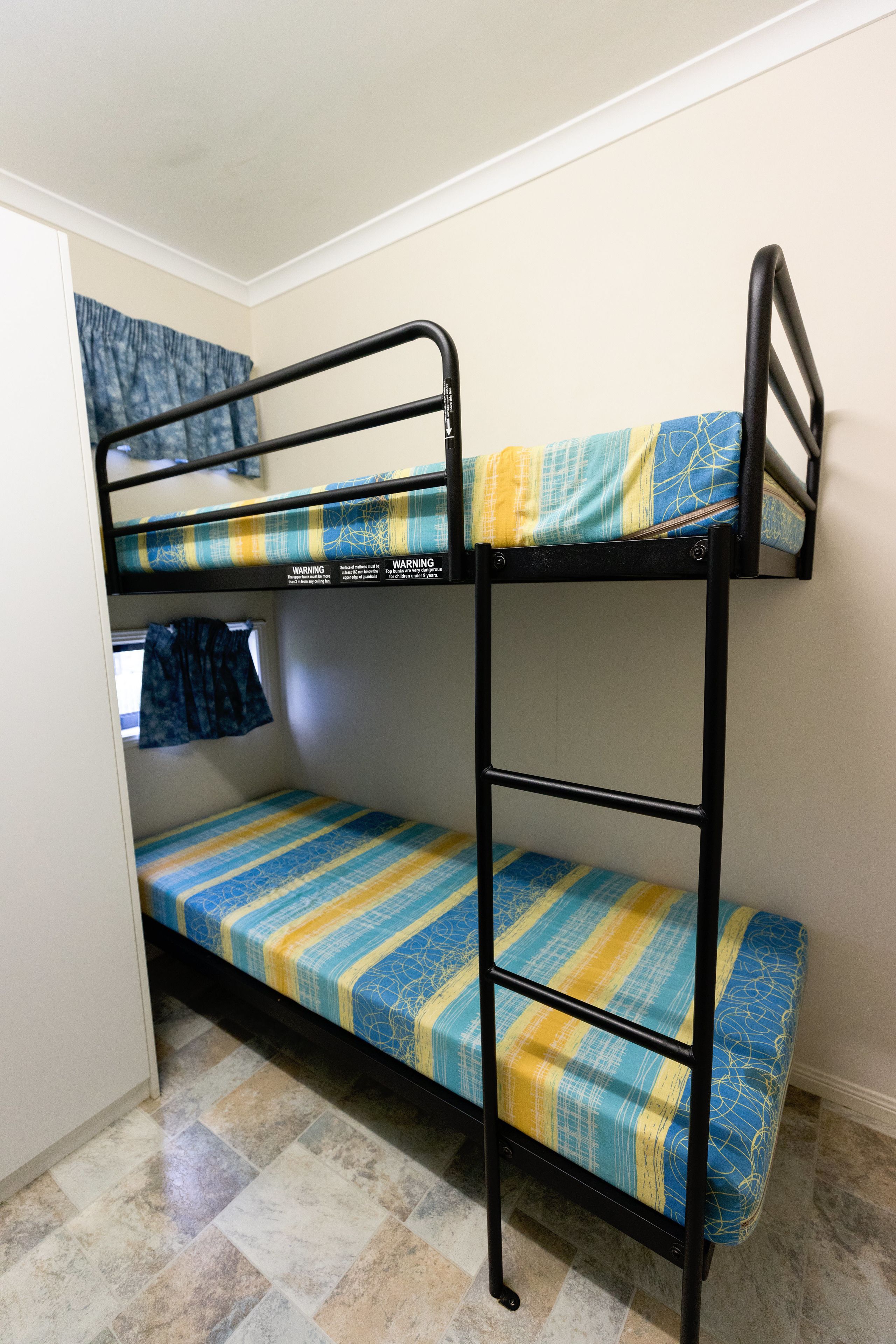 Una cama nido con colcha estampada en azul y amarillo.