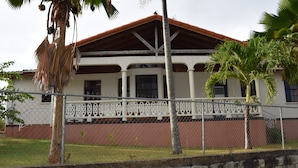 A two-story building with a red-tiled roof, white columns, and a balcony with a white railing. - Eullen Villa (Arthurs Seat)