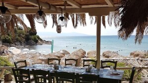 Un área de comedor al aire libre con vista a la playa y al océano.