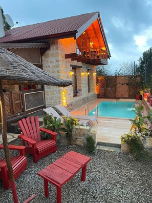 A stone building with a pool, red outdoor furniture, and a covered seating area. - Agva Heaven Hill (Sile)