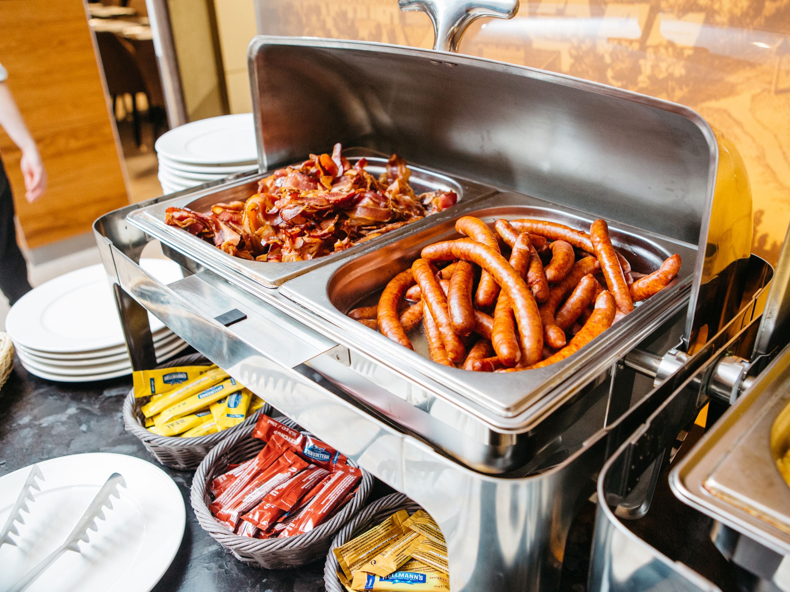 A buffet with various food items including sausages and bacon.