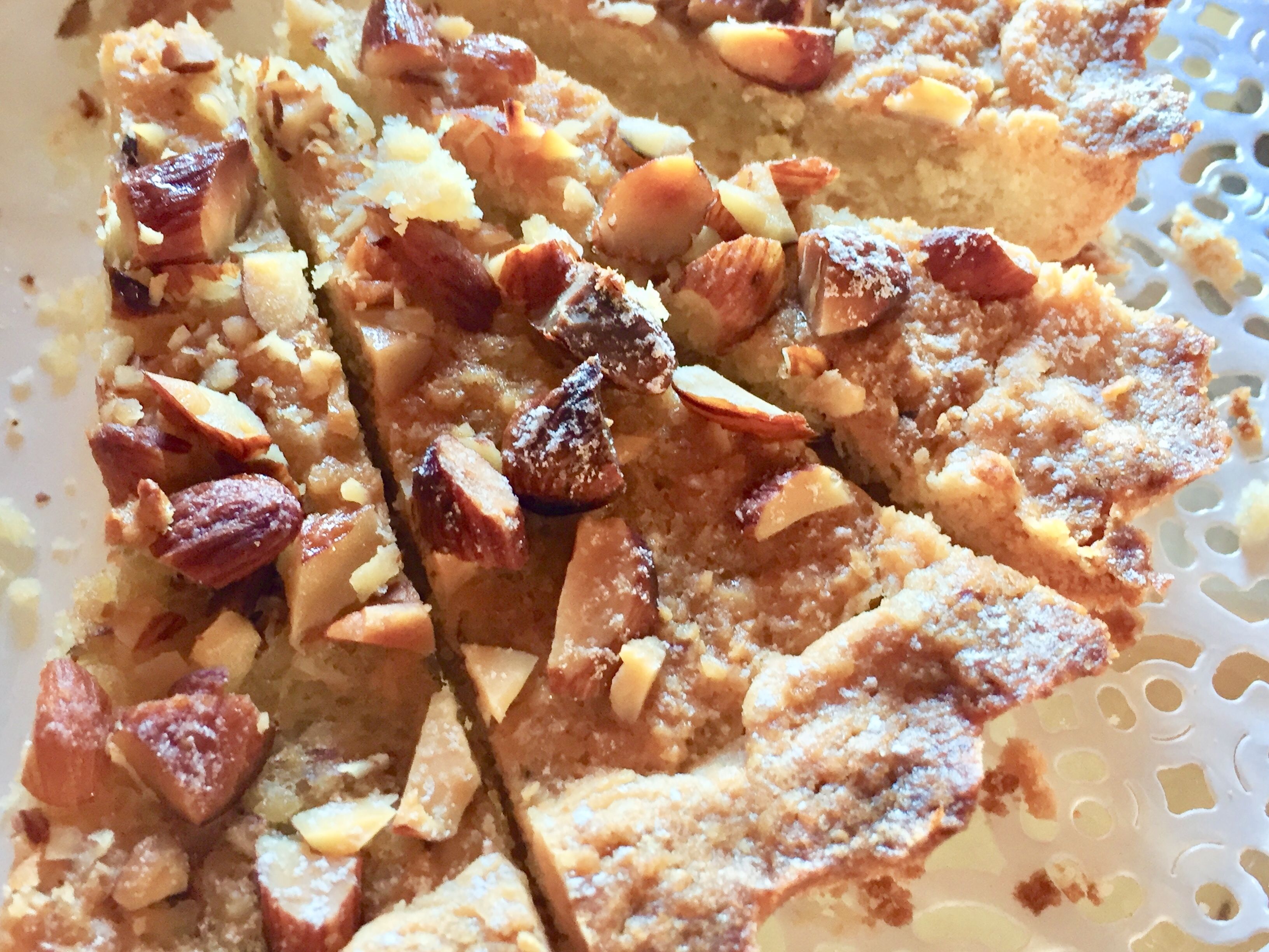 A close-up of a dessert with nuts and powdered sugar.