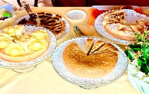 A table with various desserts on lace doilies. - Locanda Vesuna (Trequanda)