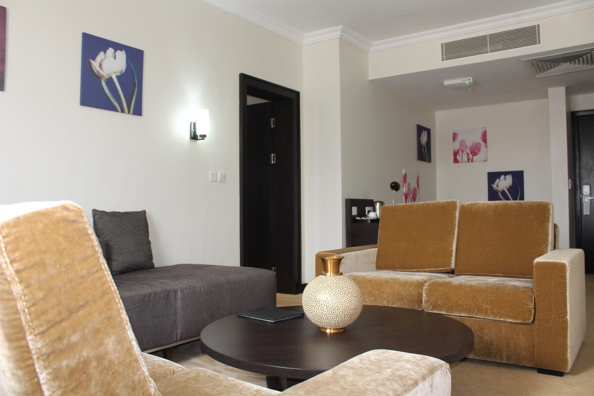 A modern living room with a sofa, armchair, and coffee table.