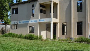 A building labeled "Le Savanna Meeting Rooms" with a flat facade, multiple windows, and a grassy area in front. - Le Savanna Country Lodge And Hotel (Kisumu)