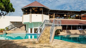 Ein Poolbereich mit überdachter Sitzgelegenheit und Treppe zu einem überdachten Bereich.