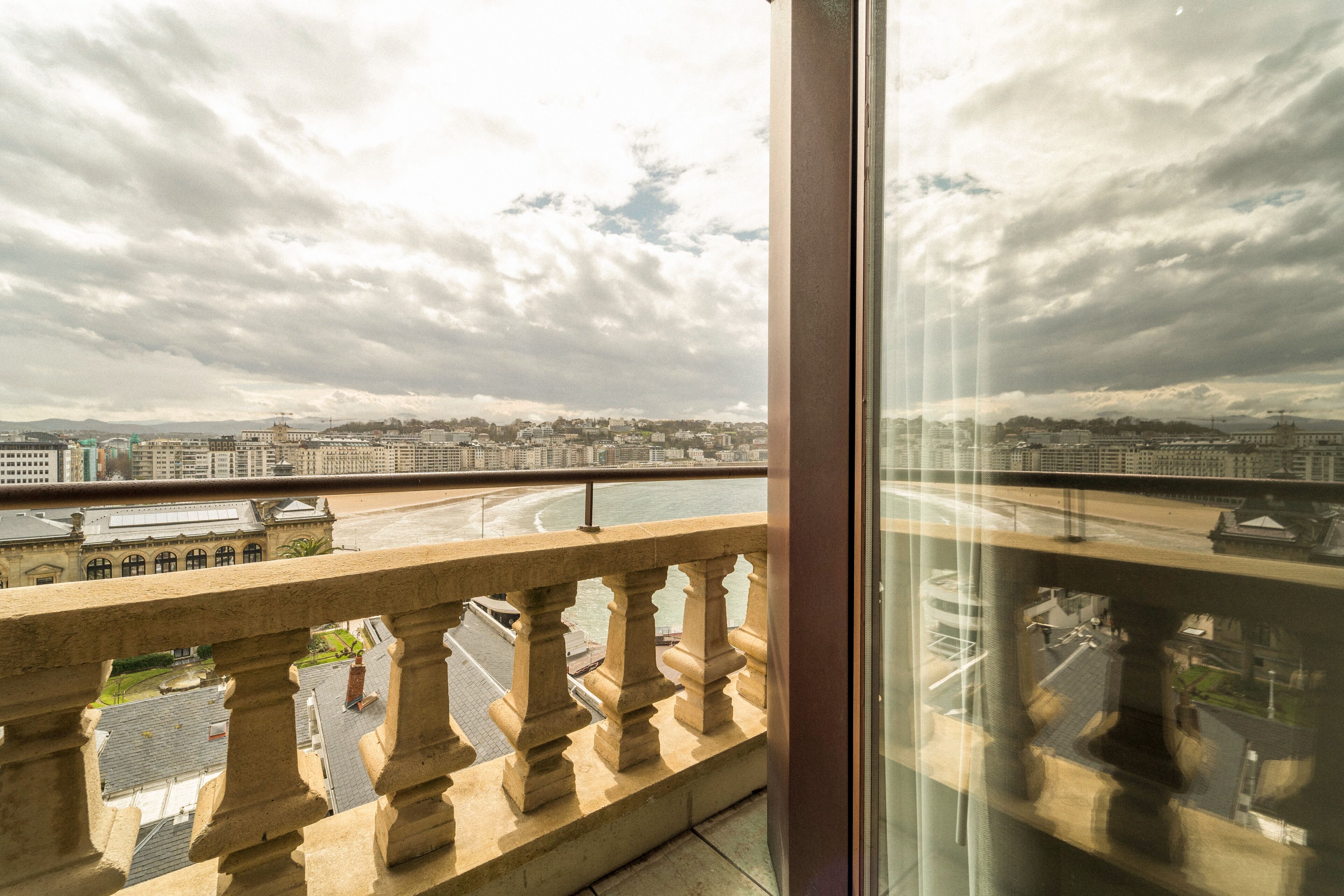 Ein Balkon mit Blick auf eine Stadtlandschaft und ein Gewässer.