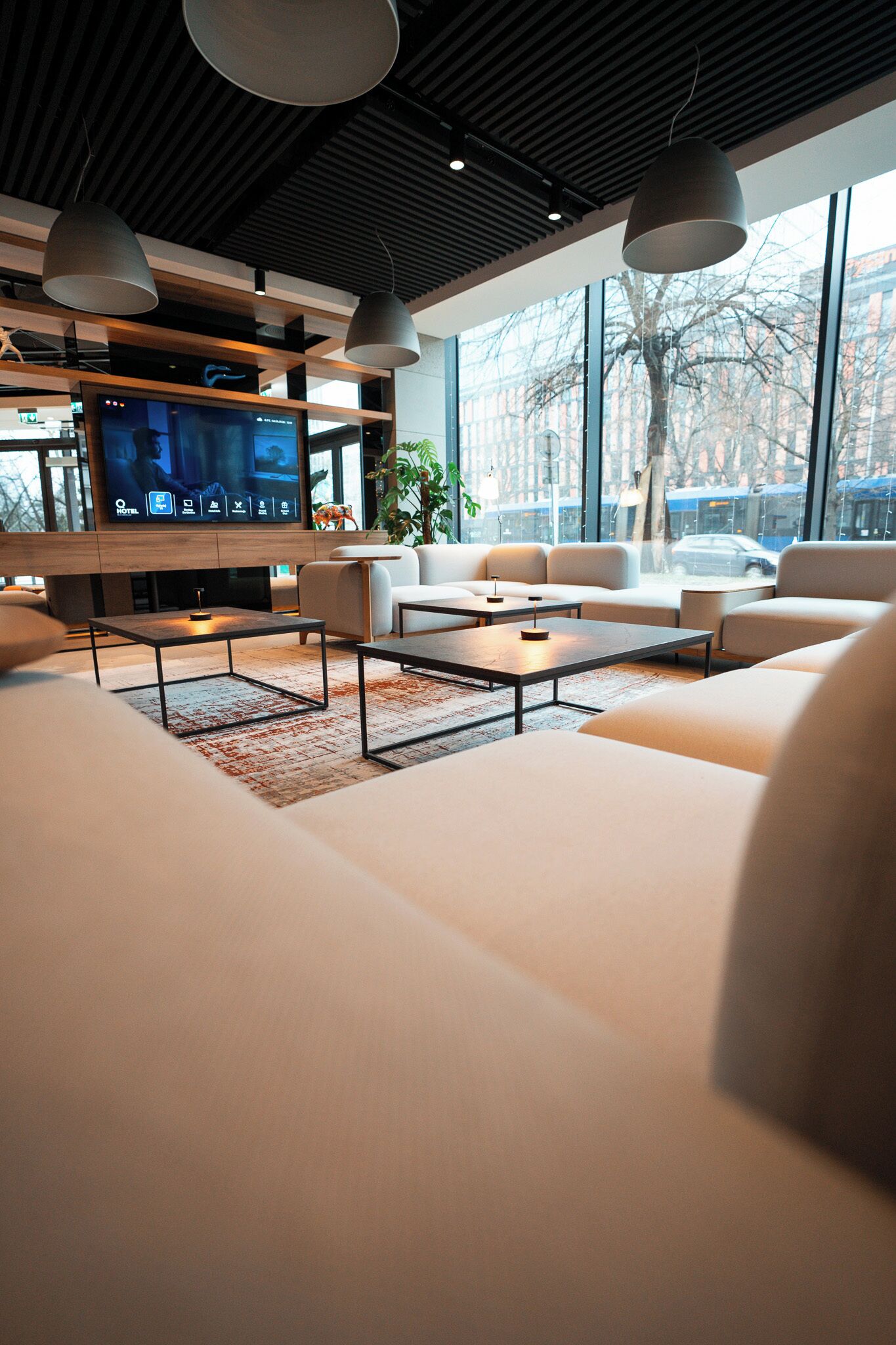 A modern living room with a flat-screen TV, sofas, and a coffee table.